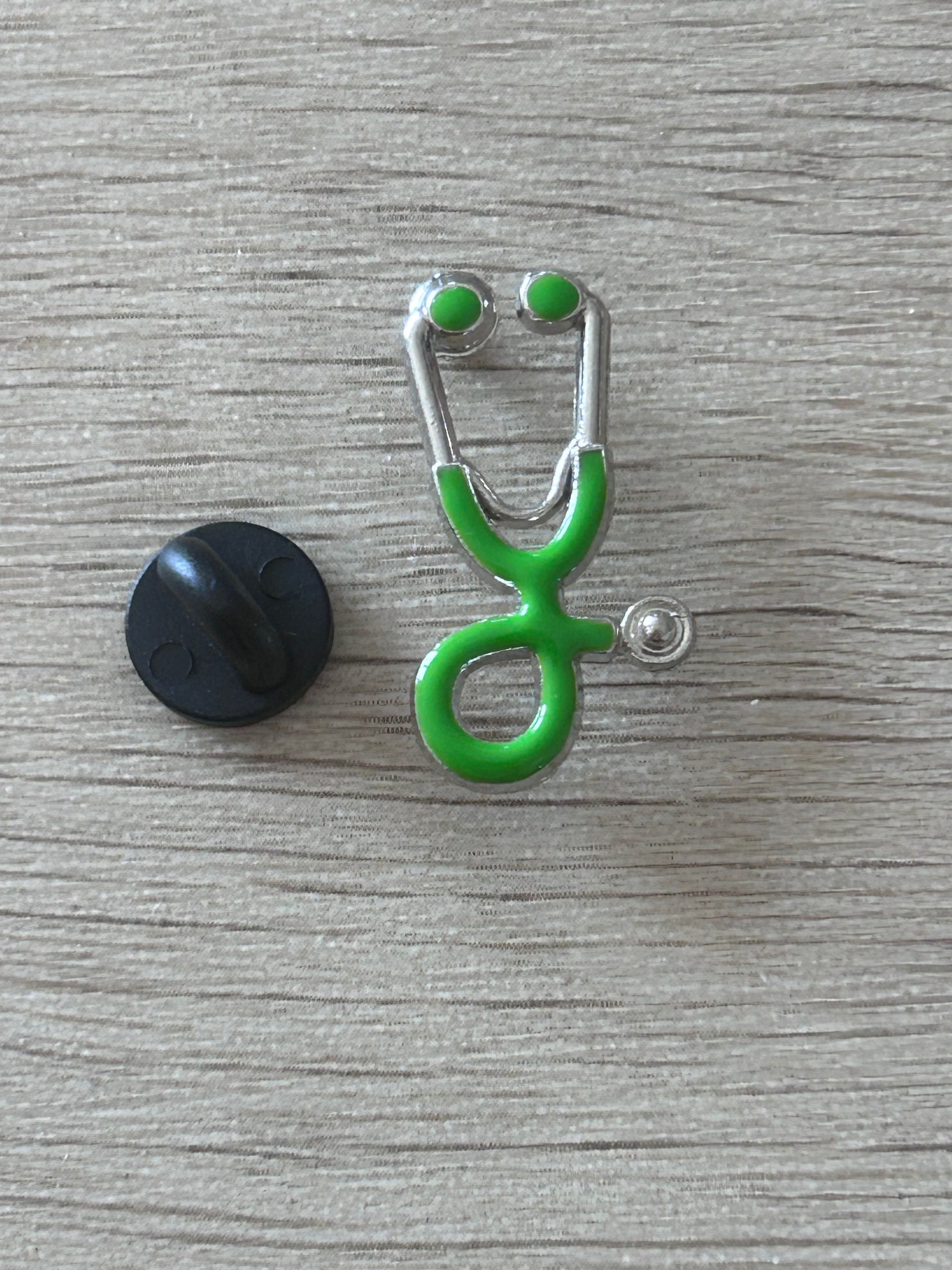 Pin's stéthoscope vert vif, contour argenté, fixation papillon