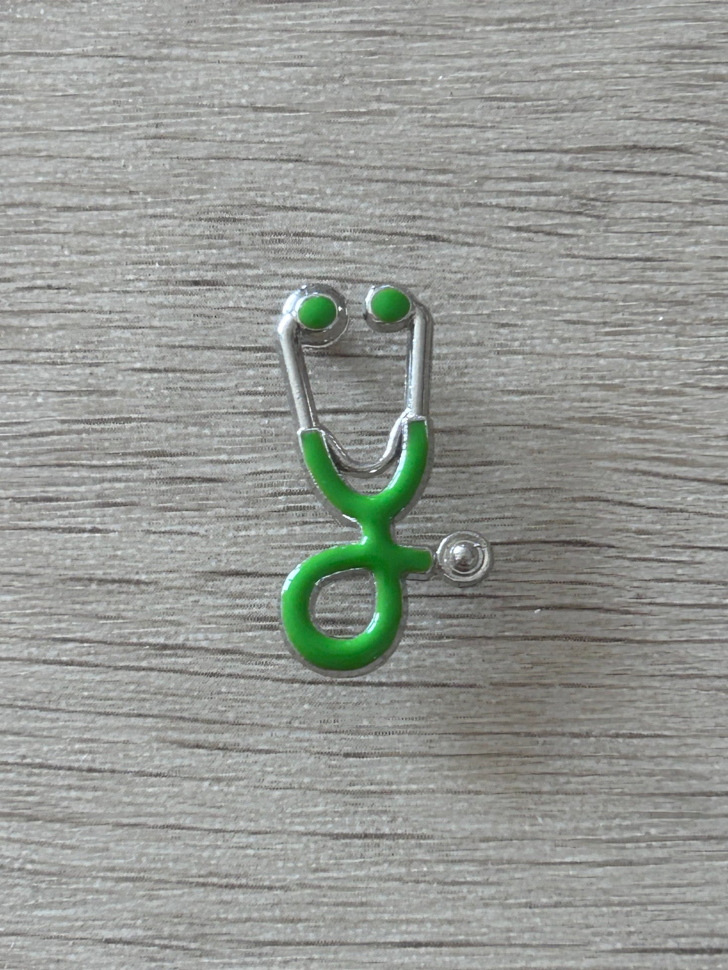 Pin's stéthoscope vert vue de face, émail vert et contour argenté