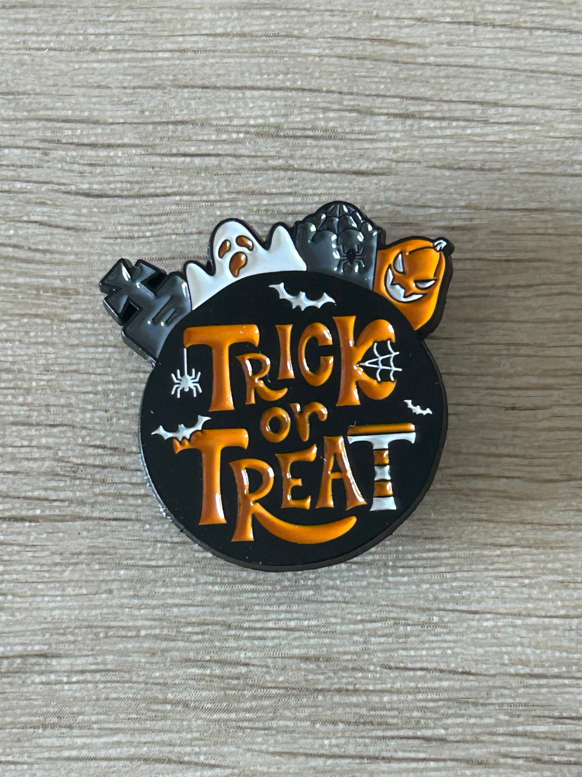 Vue rapprochée du pin's Trick or Treat et de ses motifs d’Halloween