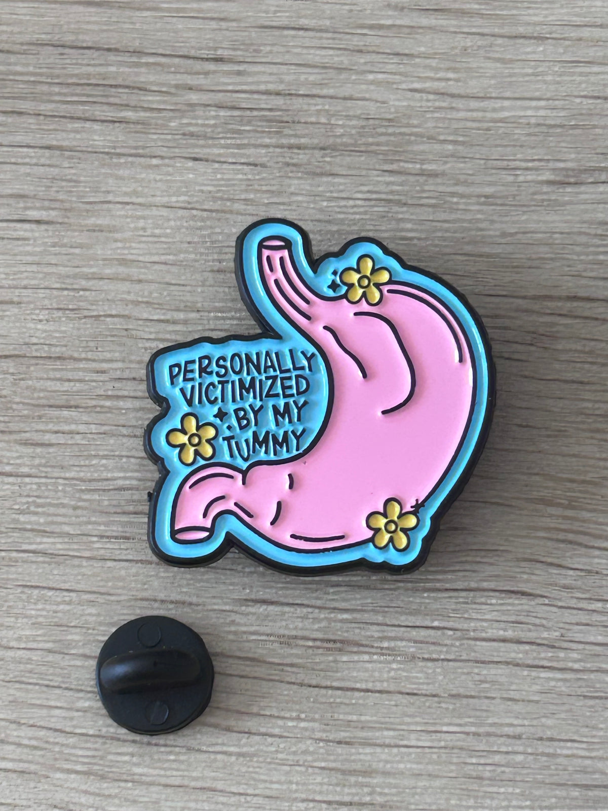 Pin's flamant rose coloré avec le message Personally victimized by my tummy